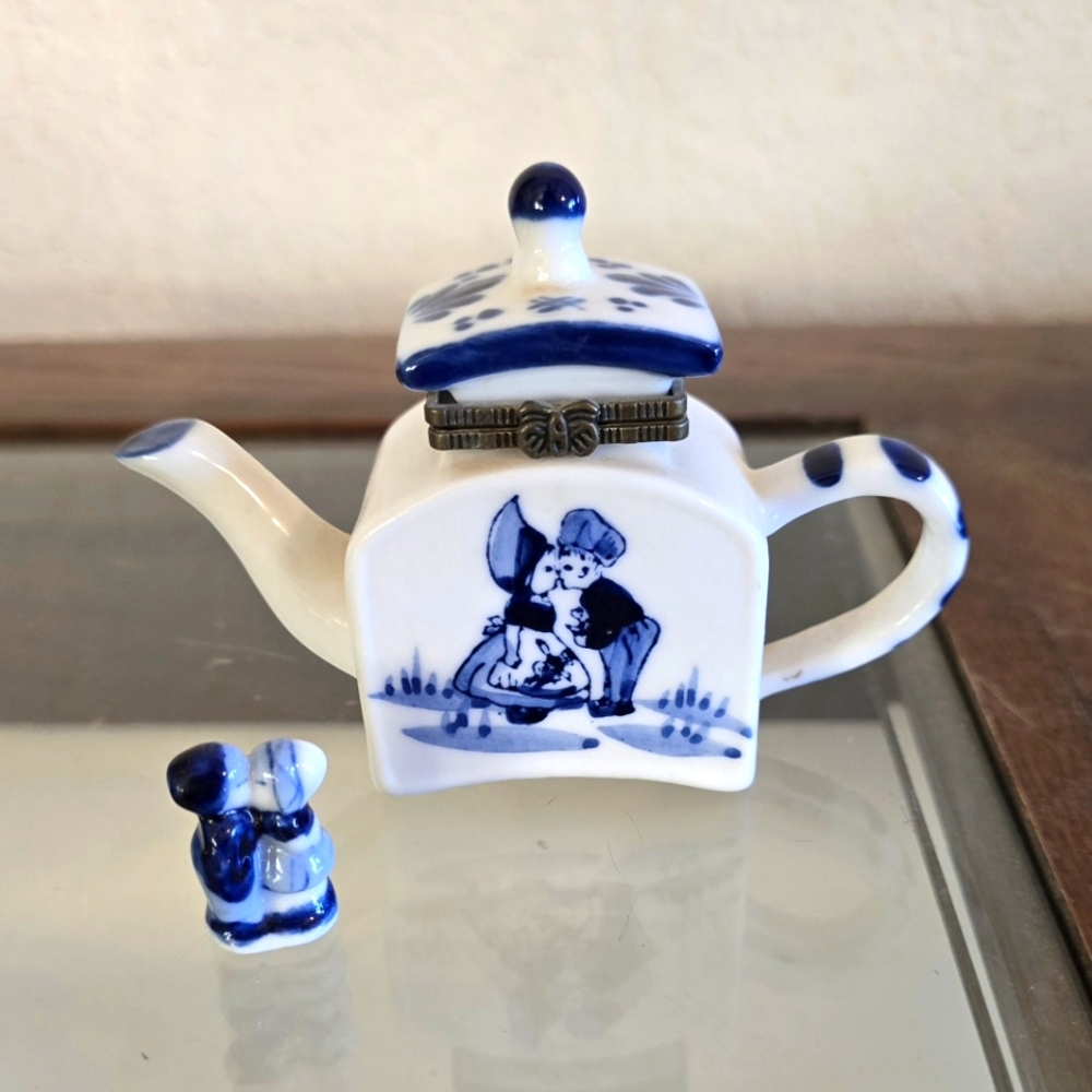 Hand painted porcelain miniature trinket box with hidden kissing couple figure.
